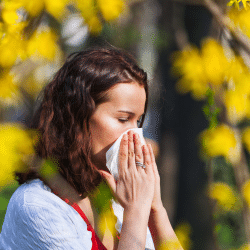 femme qui se mouche dû aux allergies aux pollens